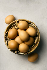 Raw eggs in a deep brown bowl on a straw pillow, top view