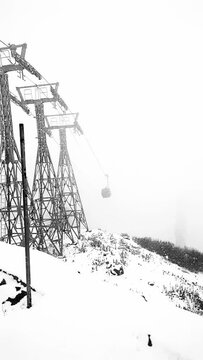 Slow motion video of the Gondola at Gulmarg, Jammu and Kashmir approaching towards the phase one station on a foggy overcast afternoon.