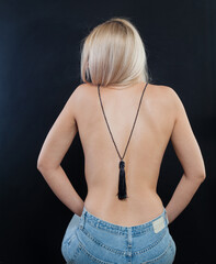 Black long necklace sautoir on female back on black background - 768594726