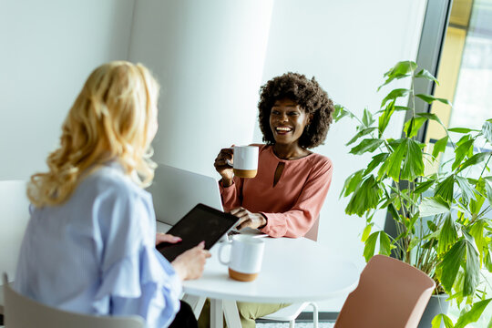 Joyful Office Coffee Break With Colleagues Sharing a Laugh in Bright Workspace