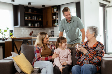 Joyous Family Celebrating Grandmothers Birthday With Cake in a Cozy Living Room - 768598388