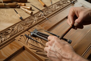carver using chisels on a solid wood cabinet door