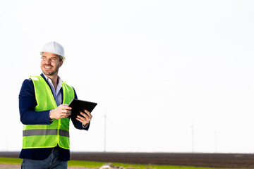 Engineer Inspecting Wind Turbine Efficiency in Vast Green Field on a Sunny Day. - 768598928