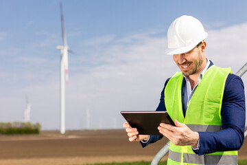 Smiling Engineer With Tablet Inspecting Wind Turbines On A Sunny Day. Generative AI - 768598974
