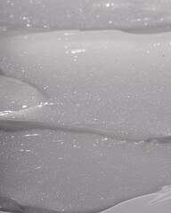 Fototapeta premium The texture of a radiant highlighting body lotion, shot in macro. Body cream texture.