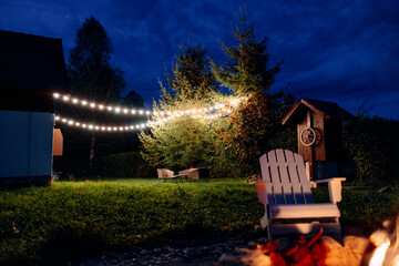 Backyard Retreat Illuminated by String Lights Among Trees, Radiant Fire Pit, Rustic Barn
