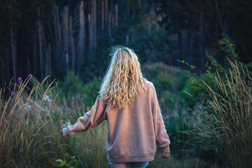 Young Blonde Girl Walking in Dark Forest - 768611353