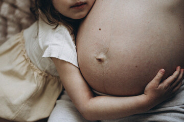A girl is hugging mother's belly
