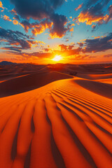 A breathtaking desert landscape basks in the orange glow of the setting sun with rippling sand dunes stretching towards the horizon under a vivid sky.