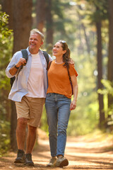 Loving Senior Retired Couple Hugging Hiking Along Trail In Countryside - 768620377
