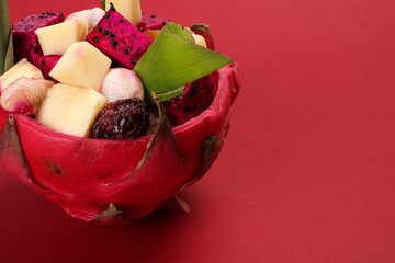 Beautiful Mangosteen mango dragon fruit cube fruit salad in dragon fruit skin bowl on red background - 768621517
