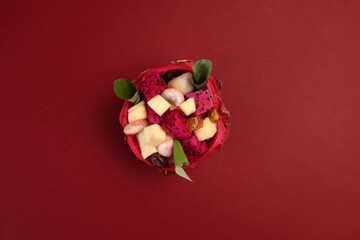 Beautiful Mangosteen mango dragon fruit cube fruit salad in dragon fruit skin bowl on red background - 768622108