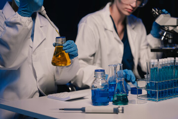 Life scientists researching in laboratory. Focused female life science professional pipetting...