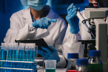 Life scientists researching in laboratory. Focused female life science professional pipetting...