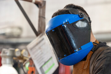 A masked worker is fully immersed in their welding task. Bright sparks fly as they focus intently...
