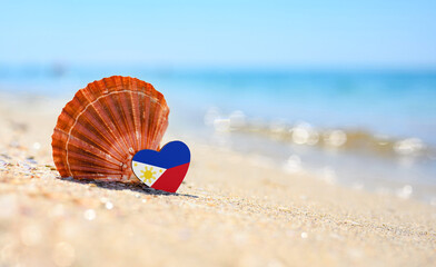 Sandy beach in Philippines. Philippines flag in the shape of a heart and a large shell. A wonderful...
