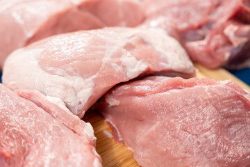 Pork meat cut into pieces lies on a cutting board. Pork meat close-up.