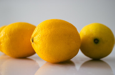 Vibrant organic lemons sit on a pristine white background, their natural beauty and fresh appeal...