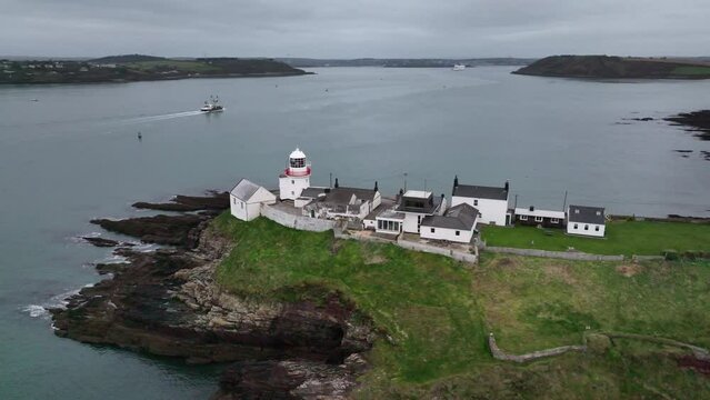 Drone video of Roches Point Lighthouse in Roches Point, East Cork, Ireland, showing a ship, Crosshaven and Cobh in the distance
