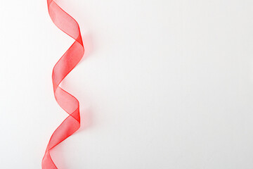 Red tulle ribbon with waves on left on white background