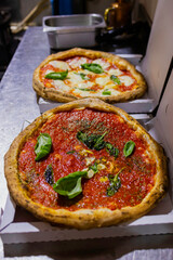 Pizza Marinara napoletana con pomodoro, basilico, acciughe, aglio e origano e Pizza Margherita napoletana con pomodoro, mozzarella e basilico pronte per essere chiuse nello scatolo per l'asporto 