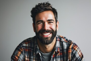 Portrait of a smiling young man in a plaid shirt.