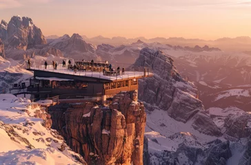 Foto op Canvas The breathtaking panorama of the Dolomites from Kitzbueghel with its snow-covered peaks, the mountain hut in front and people standing on an elevated platform enjoying the view © Kien