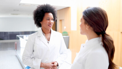 African female doctor chatting with a younger colleague