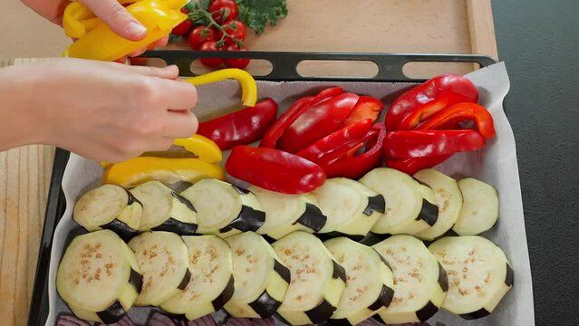 The chef arranges the vegetables on the deco to simmer, yellow zucchini, eggplant, blue onion, paprika and yellow pepper. Vegetable salad, vegetarian food, rich in vitamins. Close-up, top view