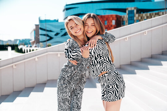 Two young beautiful smiling hipster women in trendy summer zebra print clothes. Carefree models posing in street. Positive models having fun. Cheerful and happy, at sunny day