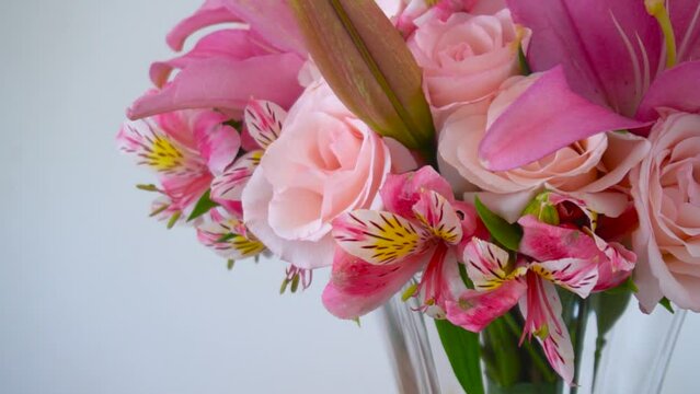 Beautiful arrangement of lilies and pink flowers in a glass vase