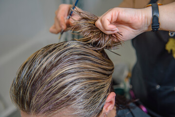 Cutting and styling wet hair after coloring. Close up