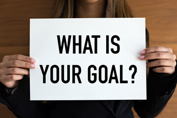 What is your goal? Woman with white page, black letters. Achievement, plan, vision, mission, objectives.