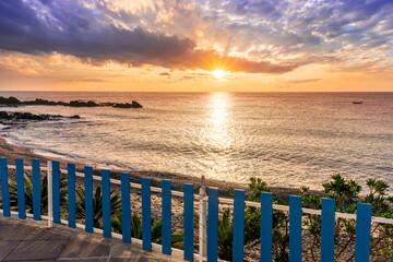amazing view from a balcony of hotel to a nice sea gulf with beautiful sunrise or sunset, rocks and water with waves.