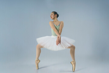 A young Japanese ballerina demonstrates balance and plasticity while standing in a plie