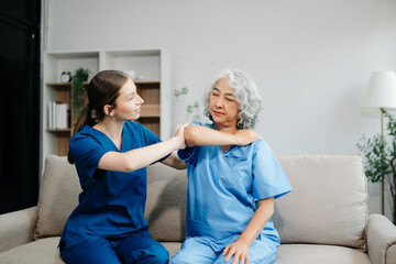 Physiotherapist helping elderly woman patient stretching arm during exercise correct in hand during...