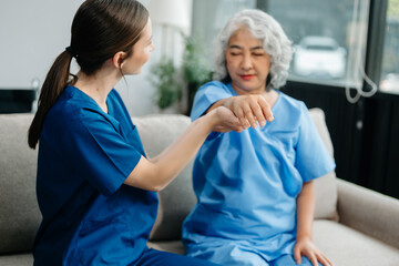 Physiotherapist helping elderly woman patient stretching arm during exercise correct in hand during...