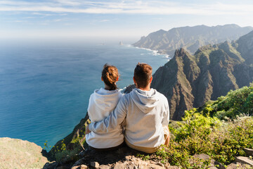 Couple enjoying vacation in nature. Hikers watching beautiful coastal scenery.