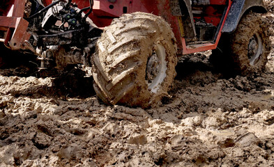 The wheels of an agricultural tractor full of mud on a country road - 768696126