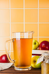 Apple cider in a glass jug on a wooden table