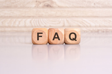 concept of FAQ word on wooden cubes, wooden background