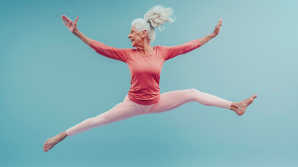 Fototapeta premium Сheerful elderly woman in yoga suit jumping in the air