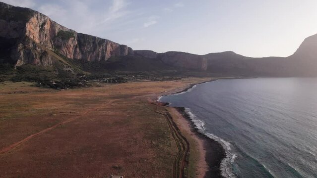 Aerial view drone of sea cost during sunset. Flying over the sea surrounded by mountains