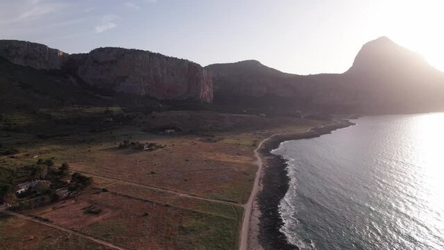 Aerial view drone of sea cost during sunset. Flying over the sea surrounded by mountains