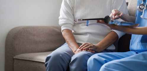 Elderly caregivers are helping to check the health and care for an elderly woman at home.