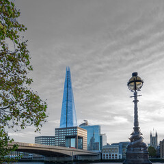 Fototapeta na wymiar London Skyline with bridge over the river thames and a stiking grey sky