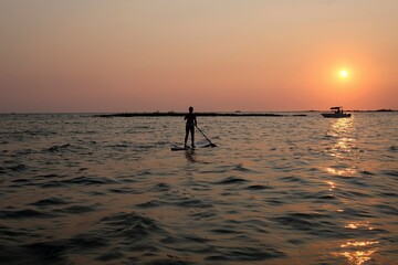 Fototapeta premium A beautiful sunset illuminates the clean and crystalline waters of Porto Cesareo, one of the most beautiful and popular tourist locations in the Puglia (Salento) region, in Italy (