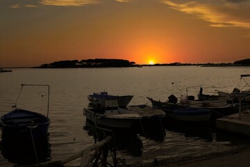 A wonderful sunset illuminates the characteristic tourist port of Porto Cesareo, one of the most...