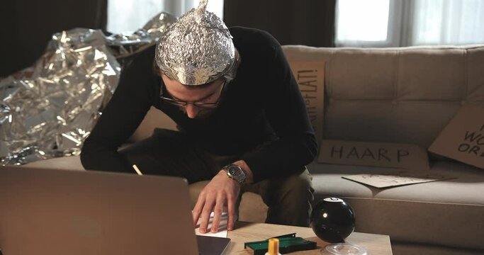 A paranoid makes notes or calculations on sheets in search of answers to pseudoscientific statements.