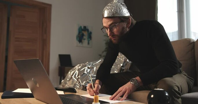 A paranoid makes notes or calculations on sheets in search of answers to pseudoscientific statements.